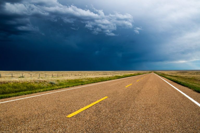 storm clouds road prairie