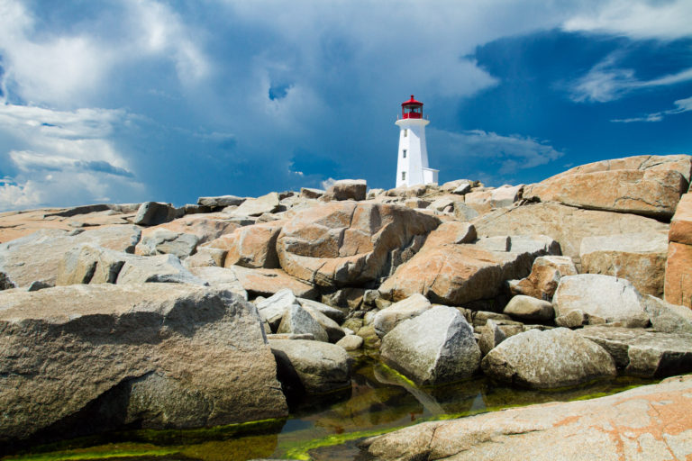 lighthouse rocks clouds