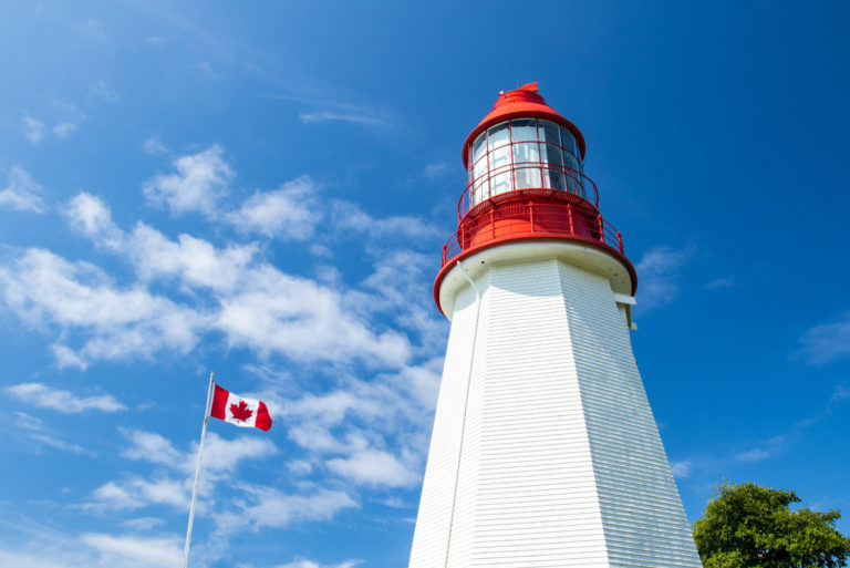 lighthouse blue sky canada flag